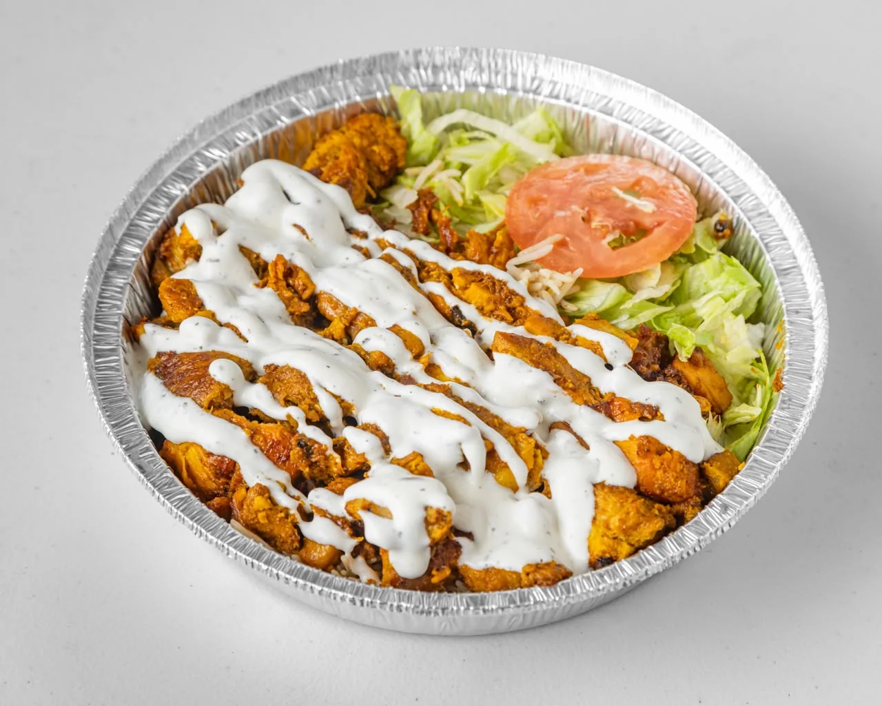 Halal platter over rice with white sauce